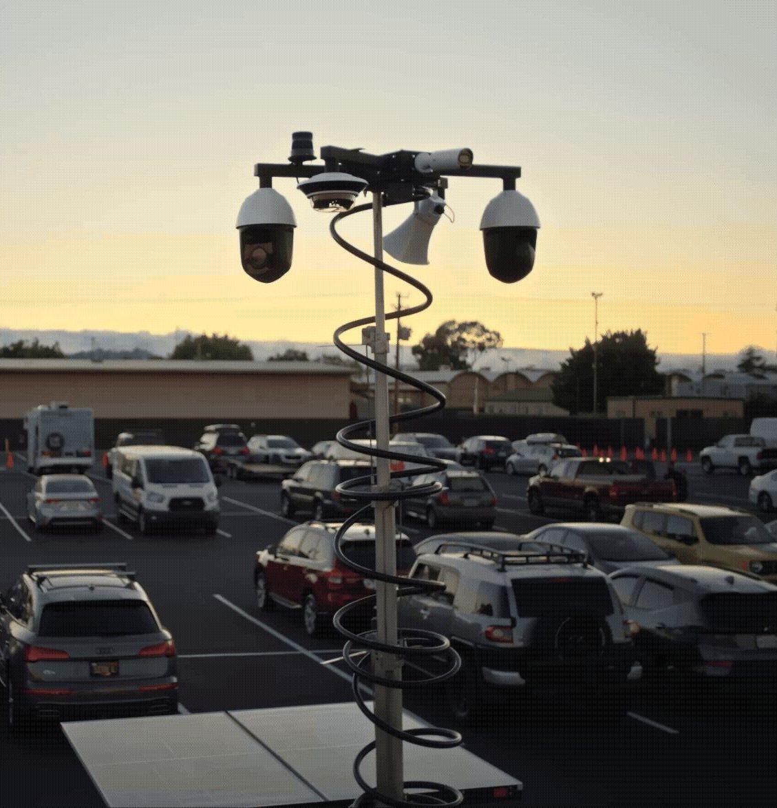 Verkada MT81 security trailer mast overlooking a monitored parking lot at dusk